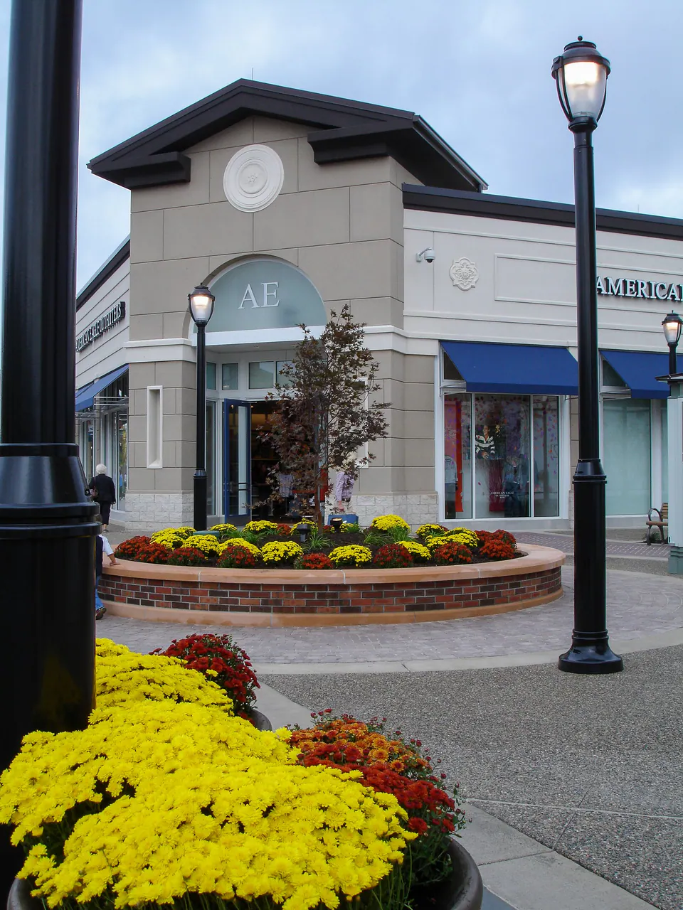 Retail storefront with curved seasonal color beds, clean walks, and maintained entry planting